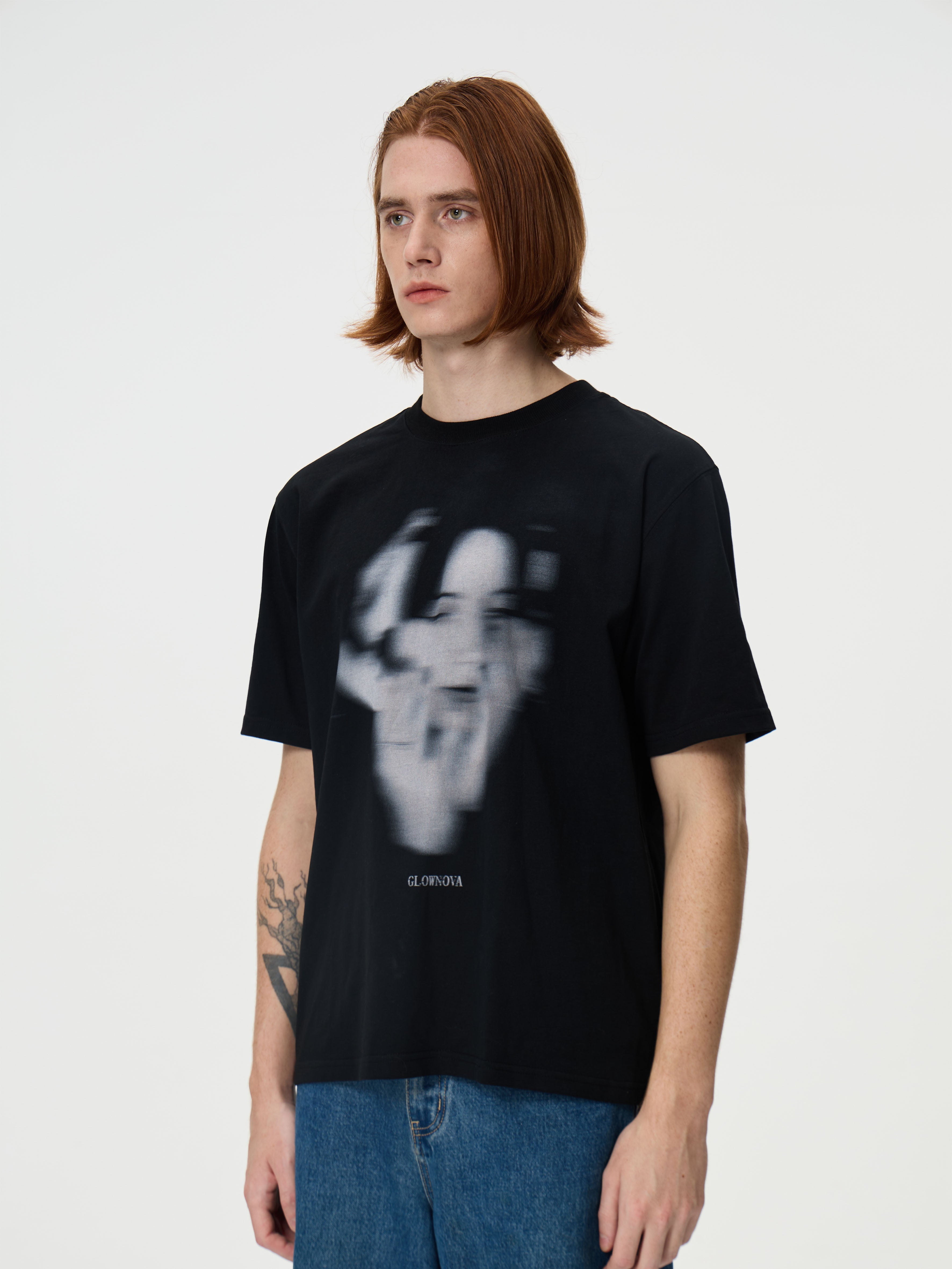 Person wearing a black t-shirt with a graphic design on a white background